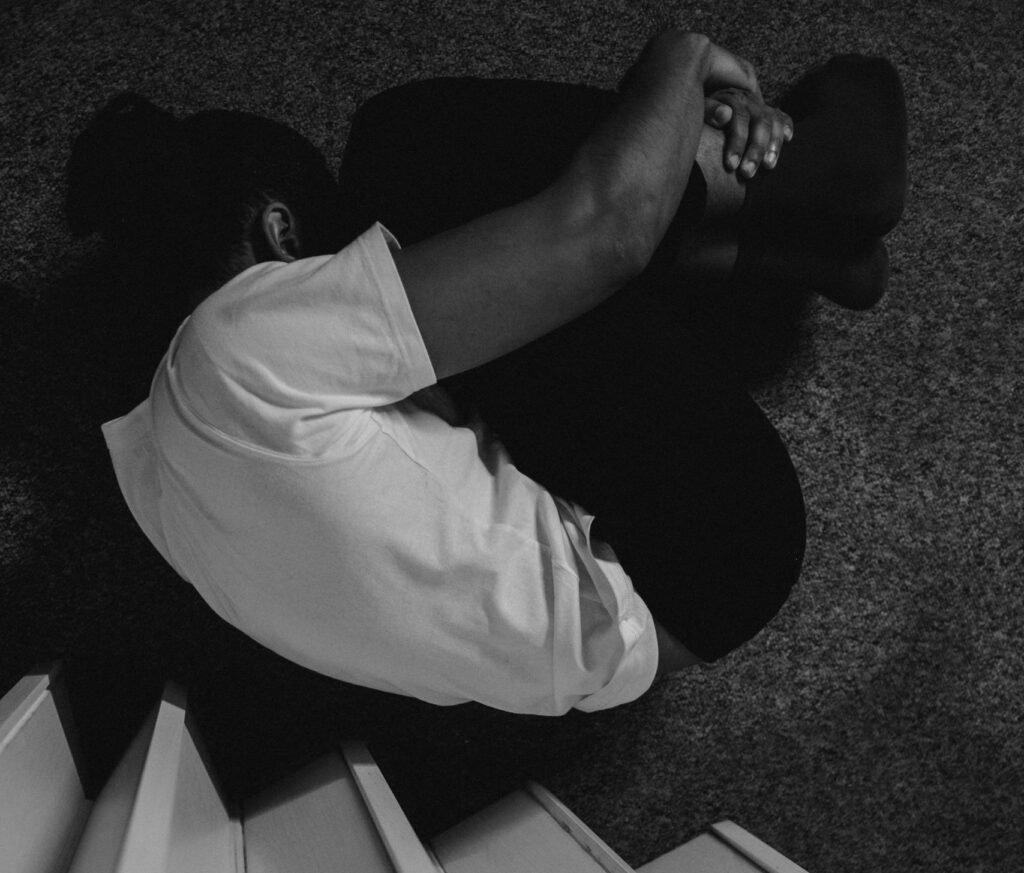 Black and white photo capturing emotional distress and introspection indoors.